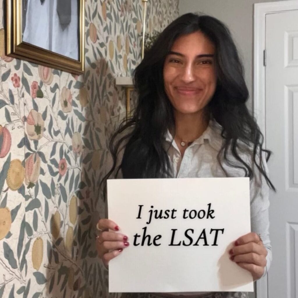 Дівчина тримає папірець з написом "Я щойно склала LSAT"
