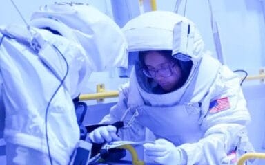 Двоє астронавтів у скафандрах працюють з обладнанням у тренувальному центрі